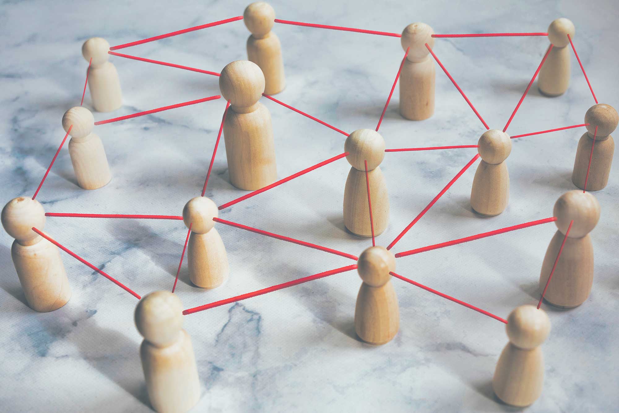 Konceptuell bild från ovan som visar träfigurer i olika storlekar