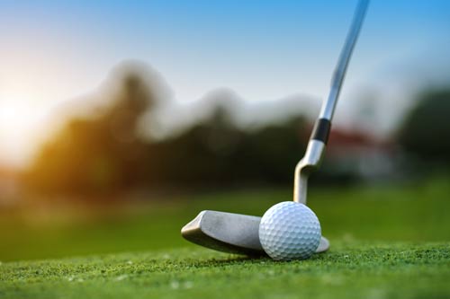 A golf club puts a ball towards the hole